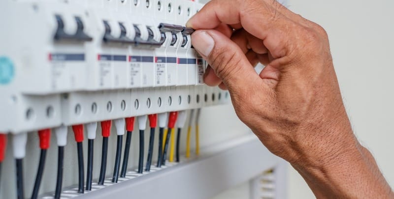 An electrician checks an electrical switchboard