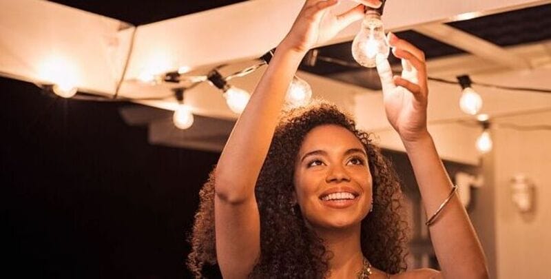 Woman puts up outdoor lighting